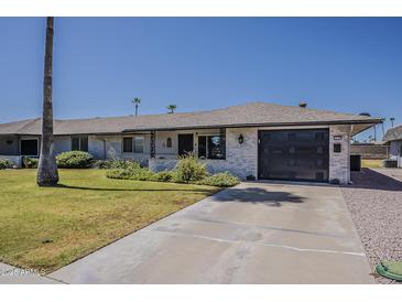 Charming single-story home with a well-manicured lawn, attached garage, and desert landscaping at 11135 W Cameo Dr, Sun City, AZ 85351