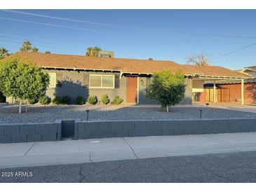 Charming single-story home featuring a well-maintained front yard and covered parking at 1801 N 87Th Pl, Scottsdale, AZ 85257