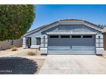 Charming single-story home featuring a well-maintained lawn and attached two-car garage at 310 E Payton St, San Tan Valley, AZ 85140