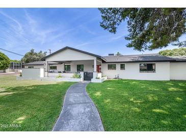 Charming home with a well-manicured lawn, inviting walkway, and covered porch area at 3102 E Mariposa St, Phoenix, AZ 85016
