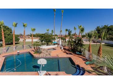 Enjoy this backyard featuring a pool, palm trees, spa, and beautiful landscaping at 5237 N 106Th Ave, Glendale, AZ 85307