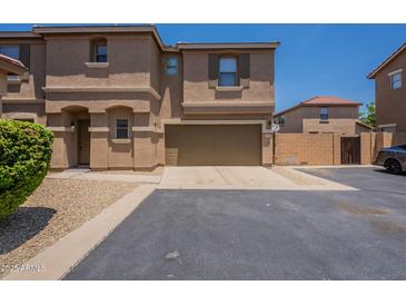 Inviting two-story townhome with a two-car garage and a well-maintained, desert-landscaped front yard at 9534 N 82Nd Ln, Peoria, AZ 85345
