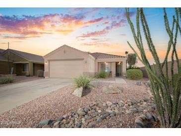 Charming single-story home with a well-manicured xeriscaped front yard and a beautiful sunset sky at 17416 W Ventura St, Surprise, AZ 85388