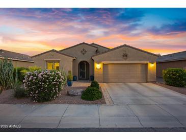 Charming single-story home featuring a two-car garage and desert landscaping beneath a vibrant sunset sky at 20194 N Riverbank Rd, Maricopa, AZ 85138
