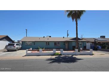 Charming single-story home with a palm tree in the front yard on a sunny day at 4810 N 69Th Dr Dr, Phoenix, AZ 85033