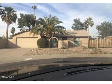Charming single-story home with desert landscaping and mature palm trees in a sunny neighborhood at 4912 E Columbine Dr, Scottsdale, AZ 85254