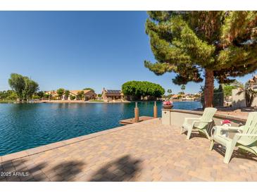 Stunning waterfront backyard featuring a patio and views of the serene lake at 608 E Stonebridge Dr, Gilbert, AZ 85234