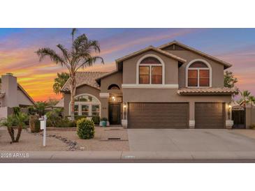 Charming two-story home with a two car garage, a well maintained landscape, and a large palm tree at 630 W Saragosa St, Chandler, AZ 85225
