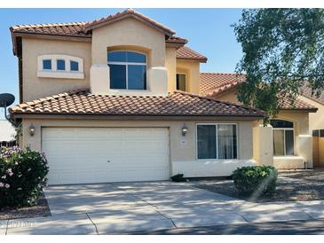 Two story home featuring tile roofing, stucco siding, attached two car garage and manicured front yard at 6923 W Laredo St, Chandler, AZ 85226