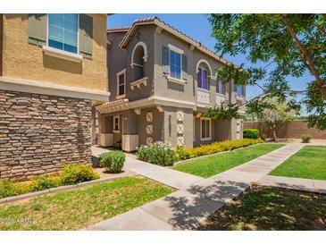 Attractive two-story townhome with a landscaped yard and inviting walkway at 9233 E Neville Ave # 1127, Mesa, AZ 85209
