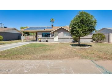 Charming single-story home featuring solar panels, a covered parking area, and a well-maintained front yard at 856 N Evergreen St, Chandler, AZ 85225