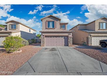 Inviting two-story home featuring a two-car garage, stone accents, and a well-manicured front yard at 11383 W Pima St, Avondale, AZ 85323