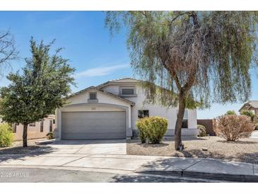 Charming single-story home with a well-manicured front yard and a two-car garage on a sunny day at 1225 N 159Th Ln, Goodyear, AZ 85338