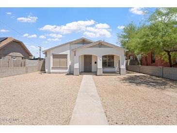 Charming single-story home featuring white stucco, front porch, and low-maintenance desert landscaping at 1510 W Fillmore St, Phoenix, AZ 85007