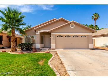 Charming single-story home with a well-manicured lawn, desert landscaping, and a two-car garage at 3940 E Heather Ct, Gilbert, AZ 85234