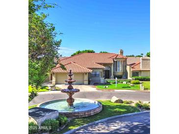 Beautiful single-Gathering home featuring a meticulously landscaped front yard and charming fountain in the circular driveway at 5431 E Piping Rock Rd, Scottsdale, AZ 85254