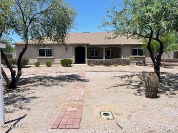 Charming single-story home with desert landscaping and a brick walkway leading to the front door at 2602 S 226Th Dr, Buckeye, AZ 85326