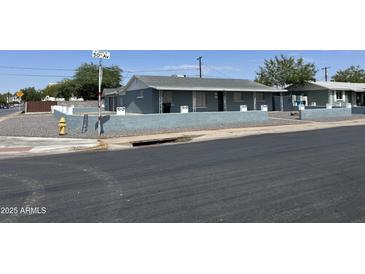 Charming single story home with a painted gray exterior and a block wall at 4502 N 50Th Ave, Phoenix, AZ 85031