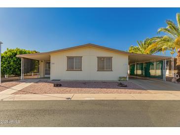 Charming single-story home with low-maintenance landscaping, carport, and mature palm trees at 8103 E Southern Ave # 69, Mesa, AZ 85209