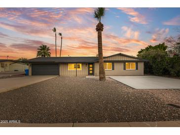 Charming home boasts desert landscaping, complemented by palm trees and a newly sealed driveway at 1911 E Lawrence Rd, Phoenix, AZ 85016