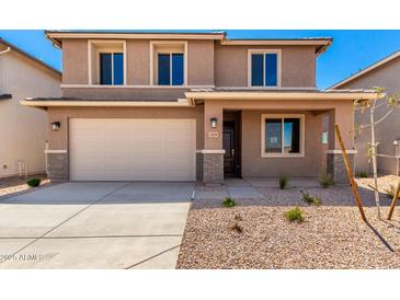 Two-story home with a front yard featuring desert landscaping, attached garage, and neutral color palette at 31850 N Bandit Rd, San Tan Valley, AZ 85143