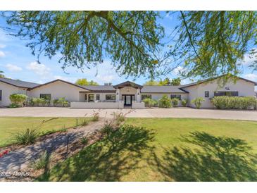 Stunning single-story home with lush lawn, manicured landscaping, and charming front entry at 8213 E Sharon Dr, Scottsdale, AZ 85260