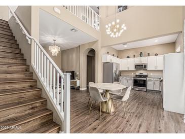 Spacious living room featuring staircase, chandelier, dining area and kitchen at 1367 S Country Club Dr # 1331, Mesa, AZ 85210