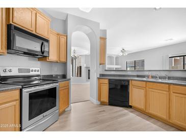 Bright kitchen features stainless steel appliances, wood cabinets, and an open view to the living area at 2565 S Signal Butte Rd # 30, Mesa, AZ 85209