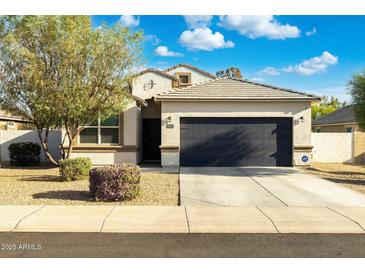 Charming single-story home with a well-maintained lawn, desert landscaping, and a two-car garage at 36033 W Catalonia Dr, Maricopa, AZ 85138