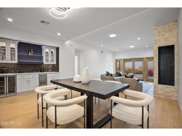Spacious living area with a sleek dining table, modern lighting, and wet bar area, perfect for entertaining at 3800 E Lincoln Dr # 31, Phoenix, AZ 85018