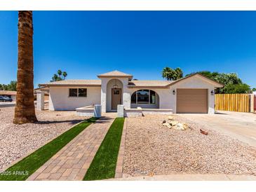 Charming single-story home featuring desert landscaping and a welcoming brick pathway to the front door at 715 S Saranac Ave, Mesa, AZ 85208