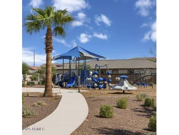 Inviting community playground featuring modern play structures, slides, and a shaded area, surrounded by desert landscaping at 18179 W Papago St, Goodyear, AZ 85338