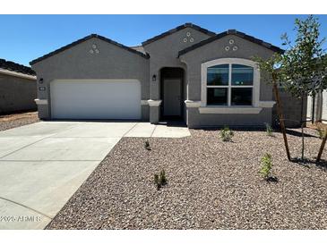 Charming single-story home with a well-maintained front yard and a two-car garage at 18331 W Hackamore Dr, Wittmann, AZ 85361