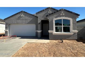 Charming single-story home featuring a two-car garage, neutral stucco, and a well-manicured yard at 18331 W Hackamore Dr, Wittmann, AZ 85361