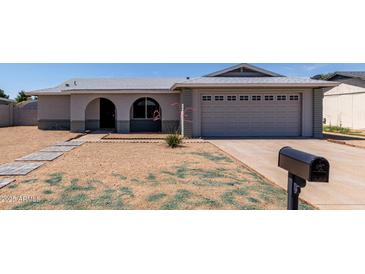 Charming single-story home with a well-maintained front yard and a two-car garage at 2233 W Oraibi Dr, Phoenix, AZ 85027