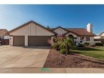 Charming single-story home featuring a terracotta roof, lush landscaping, and a spacious three-car garage at 3054 E Norwood St, Mesa, AZ 85213
