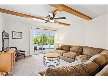 Spacious living room with a large sofa, exposed beams and a sliding glass door to the patio at 3314 N 68Th St # 129, Scottsdale, AZ 85251