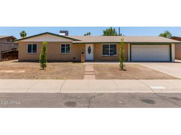 Charming single-story home featuring a well-maintained brick facade, attached garage, and minimal landscaping at 3539 W Davidson Ln, Phoenix, AZ 85051
