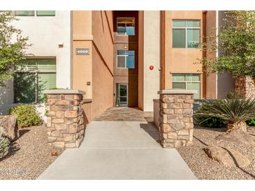 Inviting building entrance with stone pillars and landscaped surroundings at property address 4909 at 4909 N Woodmere Fairway -- # 1004, Scottsdale, AZ 85251