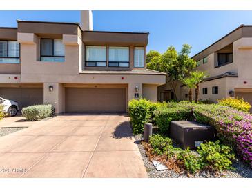 Charming townhome featuring a two-car garage and beautifully landscaped front yard at 7400 E Gainey Club Dr # 203, Scottsdale, AZ 85258