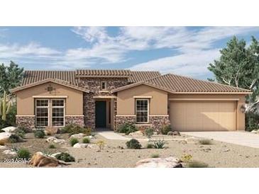 Single-story home with stucco exterior, stone accents, a tiled roof, desert landscaping, and an attached two-car garage at 20213 W San Juan Ave, Litchfield Park, AZ 85340