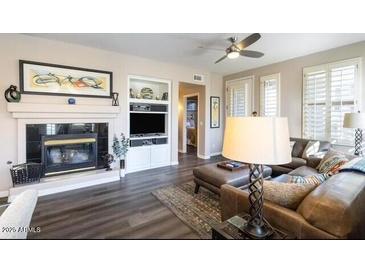 Bright living room featuring a fireplace, ceiling fan, and contemporary furnishings at 15221 N Clubgate Dr # 2096, Scottsdale, AZ 85254