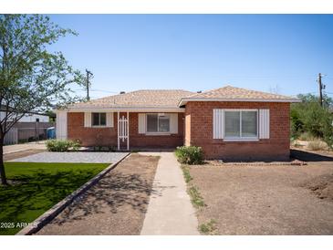 Charming brick home featuring updated landscaping and a well-manicured front yard at 1721 W Earll Dr, Phoenix, AZ 85015