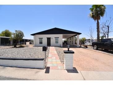 Charming home with a covered carport, mature landscaping, and a walkway leading to the front door at 2815 W Ohio St, Apache Junction, AZ 85120