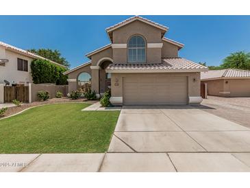 Beautiful two-story home with a spacious driveway, desert landscaping, and a tile roof at 1705 W Lark Dr, Chandler, AZ 85286