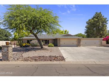 Charming single-story home with a lush green tree, desert landscaping and a spacious three-car garage at 4212 W Tierra Buena Ln, Phoenix, AZ 85053
