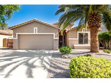 Charming single-story home featuring a manicured front yard and a two-car garage at 9465 W Tonopah Dr, Peoria, AZ 85382