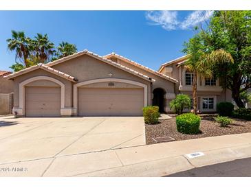 Charming two-story home showcasing a 3 car garage, desert landscaping, and tile roof at 18854 N 73Rd Dr, Glendale, AZ 85308