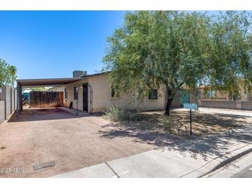 Quaint single-story home featuring a large tree, carport, and easy-to-maintain desert landscaping at 2129 N Summer St, Mesa, AZ 85203