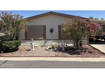 Charming home exterior with lush landscaping and decorative yard art at 3330 E Main St # 448, Mesa, AZ 85213